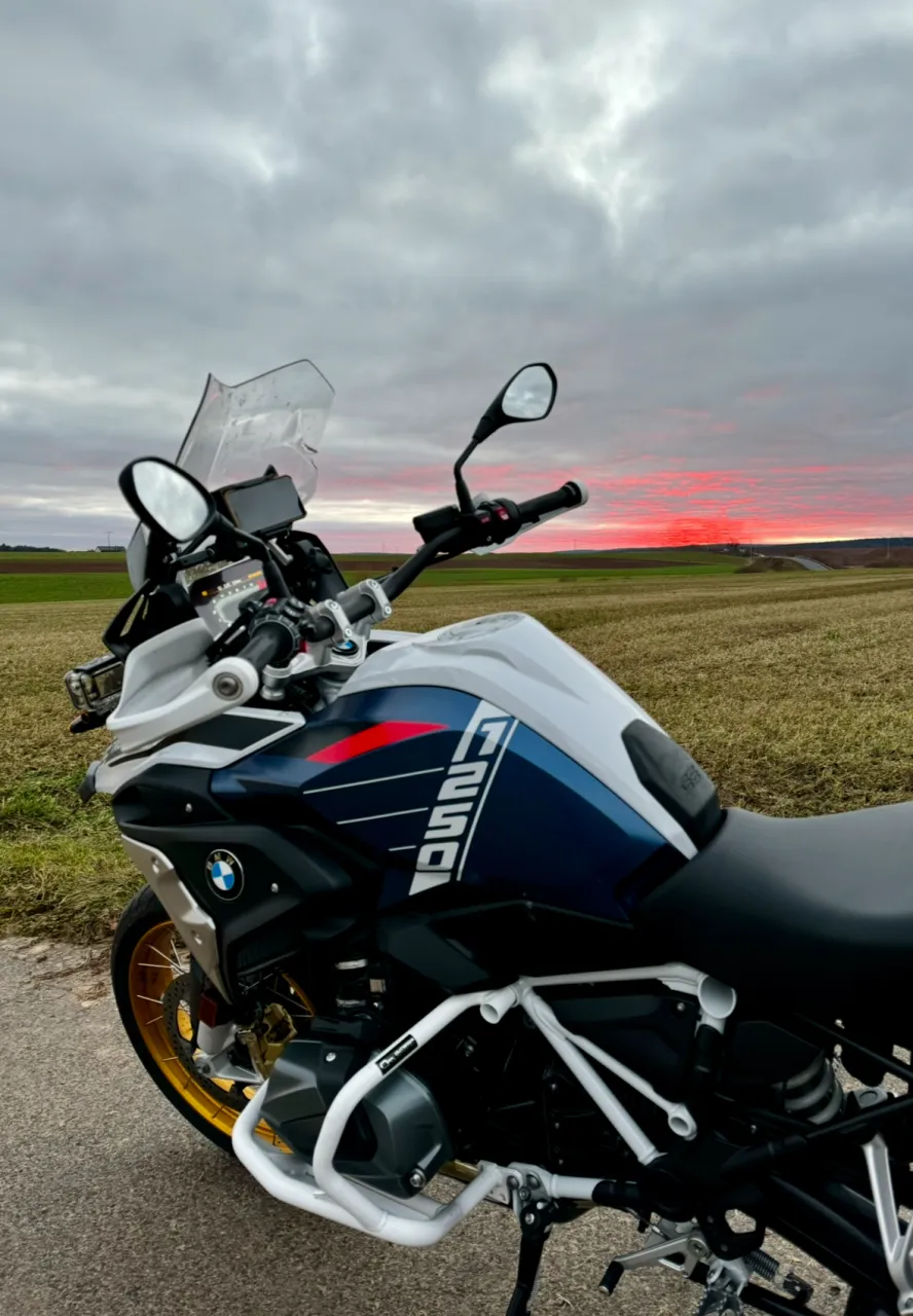 BMW-GS-Motorrad bei Sonnenuntergang auf freier Landstraße