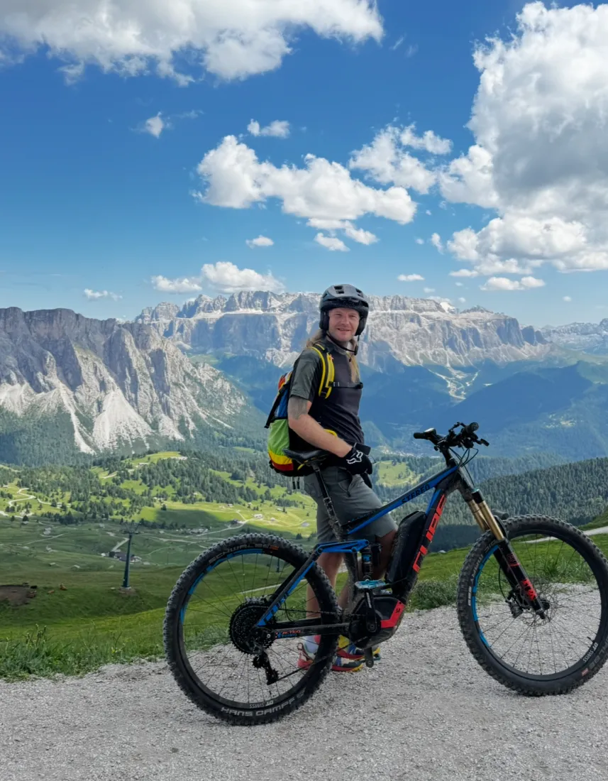 Robby mit E-Mountainbike vor Dolomiten-Panorama